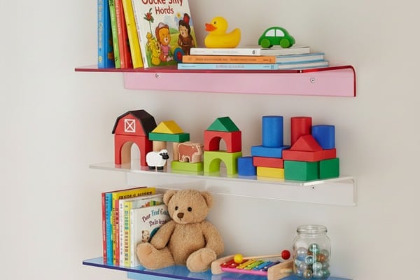 Floating glass shelves that hold books and toys 