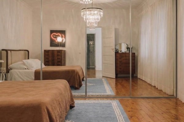 Mirror sliding wardrobes across the entire wall of the room