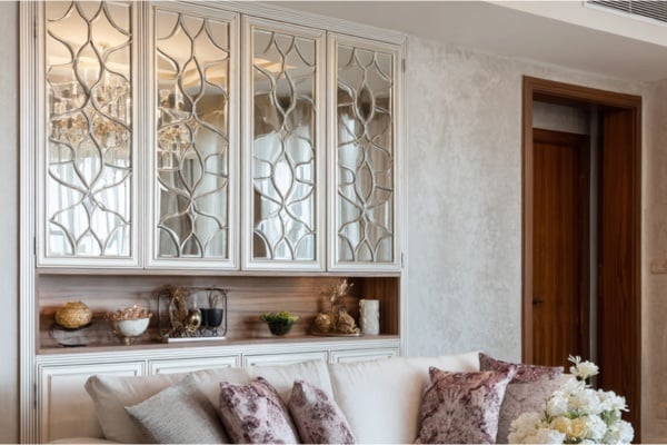Mirrored furniture reflects light while visually lightening bulky elements.